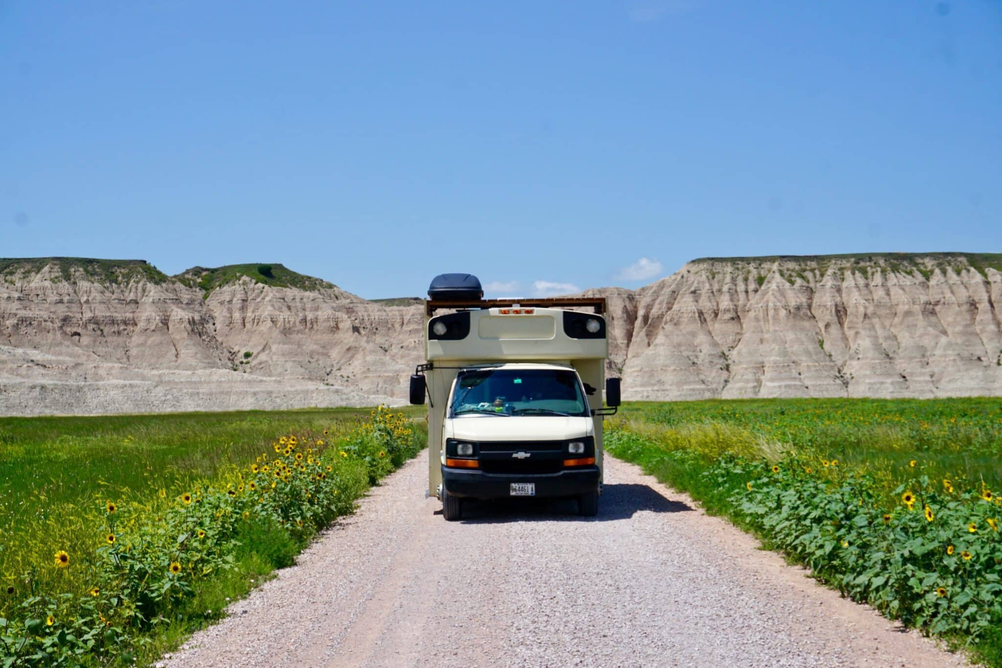 Type A short bus conversion on a gravel road in the Badlands