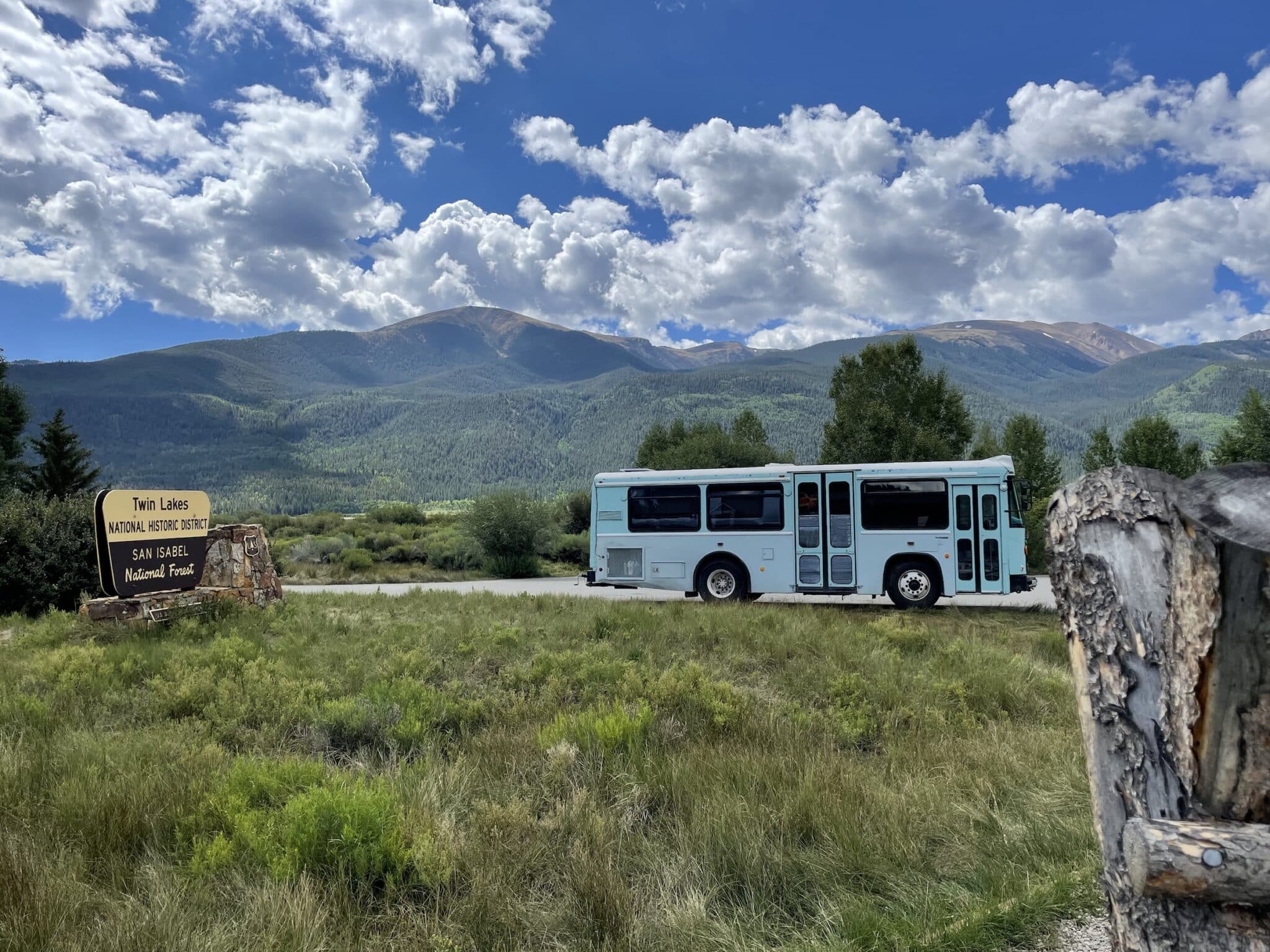 Converted bus parked at Twin Lakes National Forest with mountains in the background